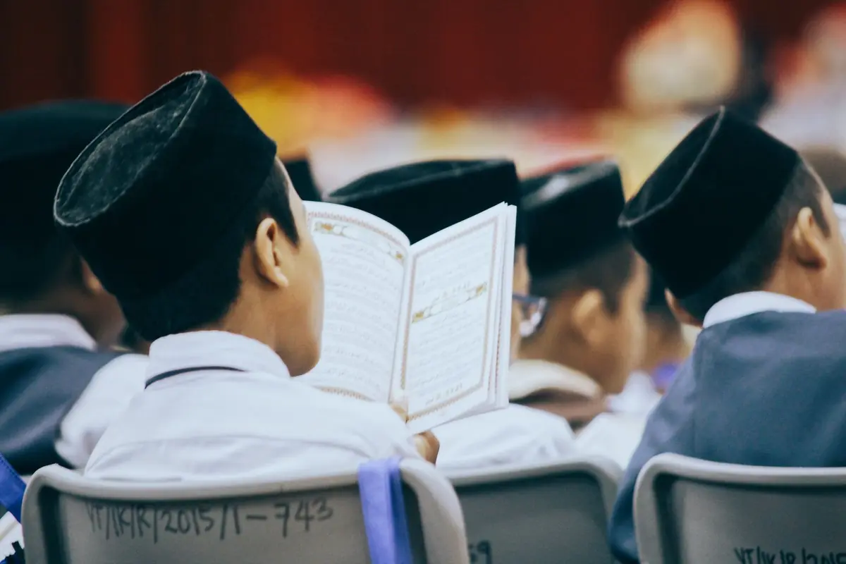 Anak-anak membuka dan membaca Al-Qur'an bersama